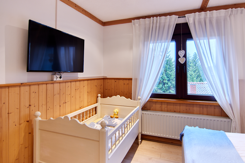 Schlafzimmer rechts mit Kinderbett- Böhms Suite in Friedrichsbrunn